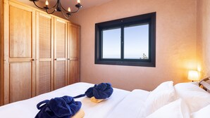 Une chambre d’hôtel avec un lit, une armoire en bois et une fenêtre donnant sur un paysage agréable.
