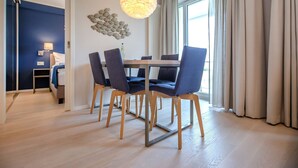 Un espace repas moderne avec une table ronde, quatre chaises et un luminaire suspendu.