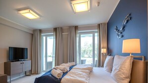 Une chambre d’hôtel avec un grand lit, une télévision et une vue sur l’extérieur par les fenêtres.