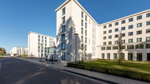 Ein modernes Gebäude mit flachem Dach, großen Fenstern und einer sauberen, weißen Fassade.