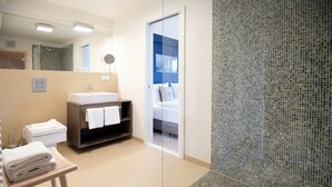 Une salle de bain moderne avec un lavabo, un miroir et un porte-serviettes.