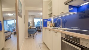 Een moderne keuken met een ingebouwde oven, een koffiezetapparaat en een spoelbak.
