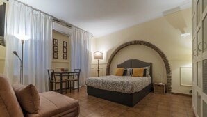 A bedroom with a bed, a chair, a table, and a lamp. - GuestHost - Nice and cozy apartment of 35 sqm, ideal for 2 people, located on the first floor of a renovated period building (not equipped with lift). The flat is located in very central position, just 200 meters from Piazza Navona and a few steps from o (Roma)