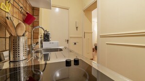 A kitchen with a stainless steel sink, a coffee maker, and utensils hanging on the wall. - GuestHost - Nice and cozy apartment of 35 sqm, ideal for 2 people, located on the first floor of a renovated period building (not equipped with lift). The flat is located in very central position, just 200 meters from Piazza Navona and a few steps from o (Roma)