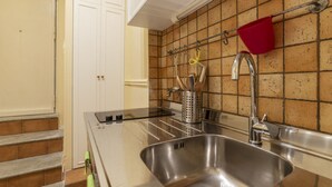A kitchen with a stainless steel sink, a red pot holder, and a utensil holder on the wall. - GuestHost - Nice and cozy apartment of 35 sqm, ideal for 2 people, located on the first floor of a renovated period building (not equipped with lift). The flat is located in very central position, just 200 meters from Piazza Navona and a few steps from o (Roma)