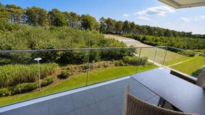 A balcony with a view of a landscaped garden and a road. - Apartment with sea view, 1 bedroom and balcony (Ostseebad Binz)
