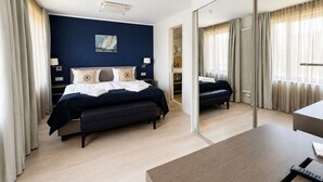 A modern hotel room with a large bed, a desk, and a mirror. - Apartment with sea view, 1 bedroom and balcony (Ostseebad Binz)