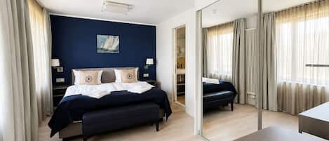 Una habitación de hotel moderna con una cama grande, un escritorio y un espejo.