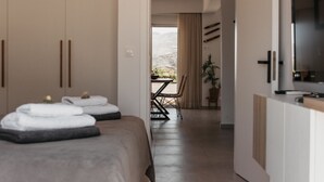 Une chambre d’hôtel moderne équipée d’un lit, d’une télévision et offrant une vue sur les montagnes.