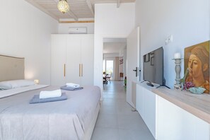 Una habitación de hotel con una cama, un televisor y un cuadro en la pared.