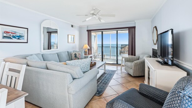 A spacious living room with a large sofa, a television, and a balcony with a view of the sea. - Enjoy beautiful ocean views at this 3 bedroom, 2 bath oceanfront condo located downtown! (Ocean City)