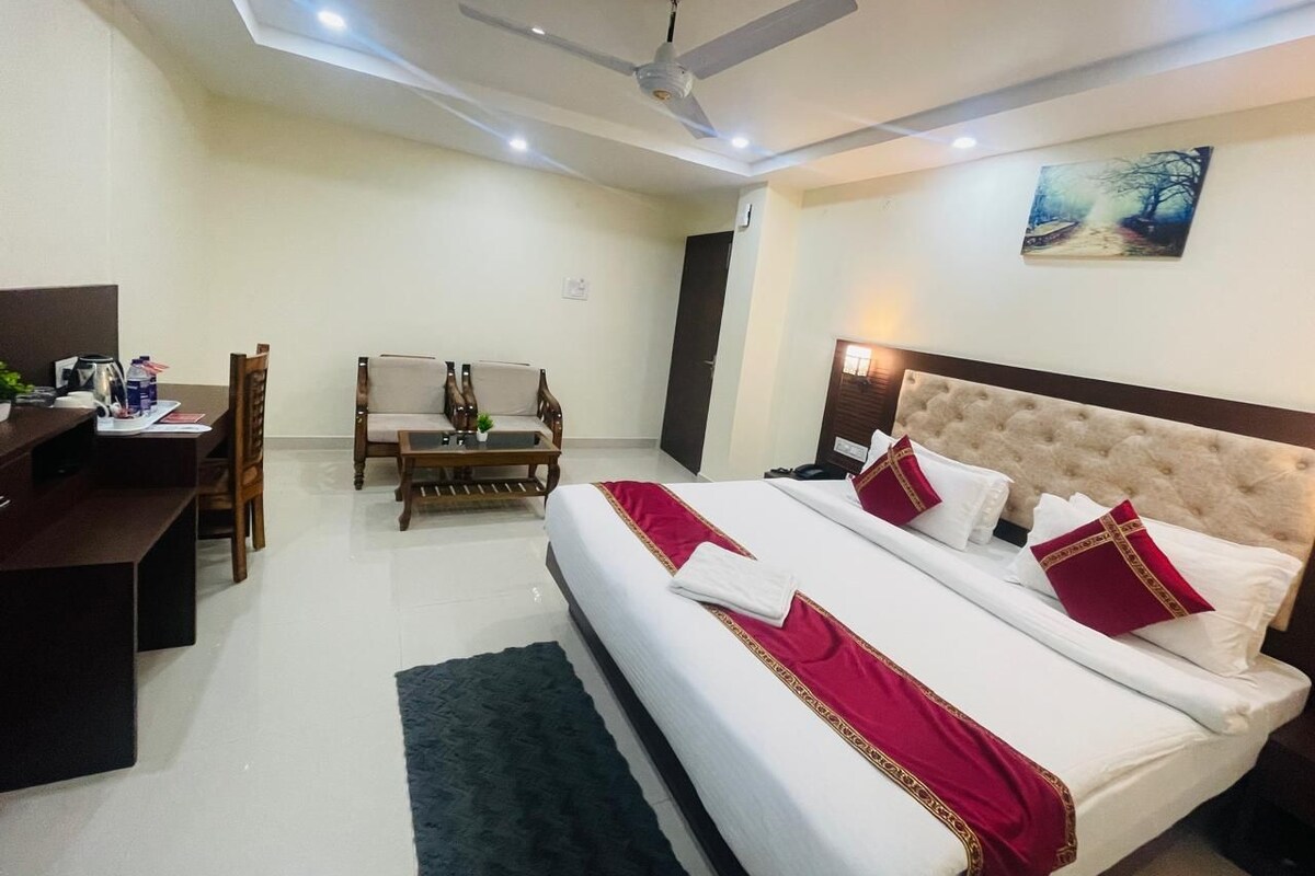 Una habitación de hotel con una cama, un escritorio, una silla y un cuadro en la pared.