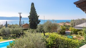 Una piscina circondata da vegetazione lussureggiante con vista sul mare.