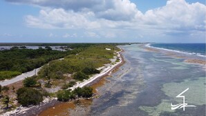 Un paysage côtier avec une route, une plage et l’océan.