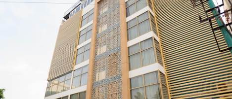A modern hotel with a prominent entrance, multiple floors, and a decorative facade.