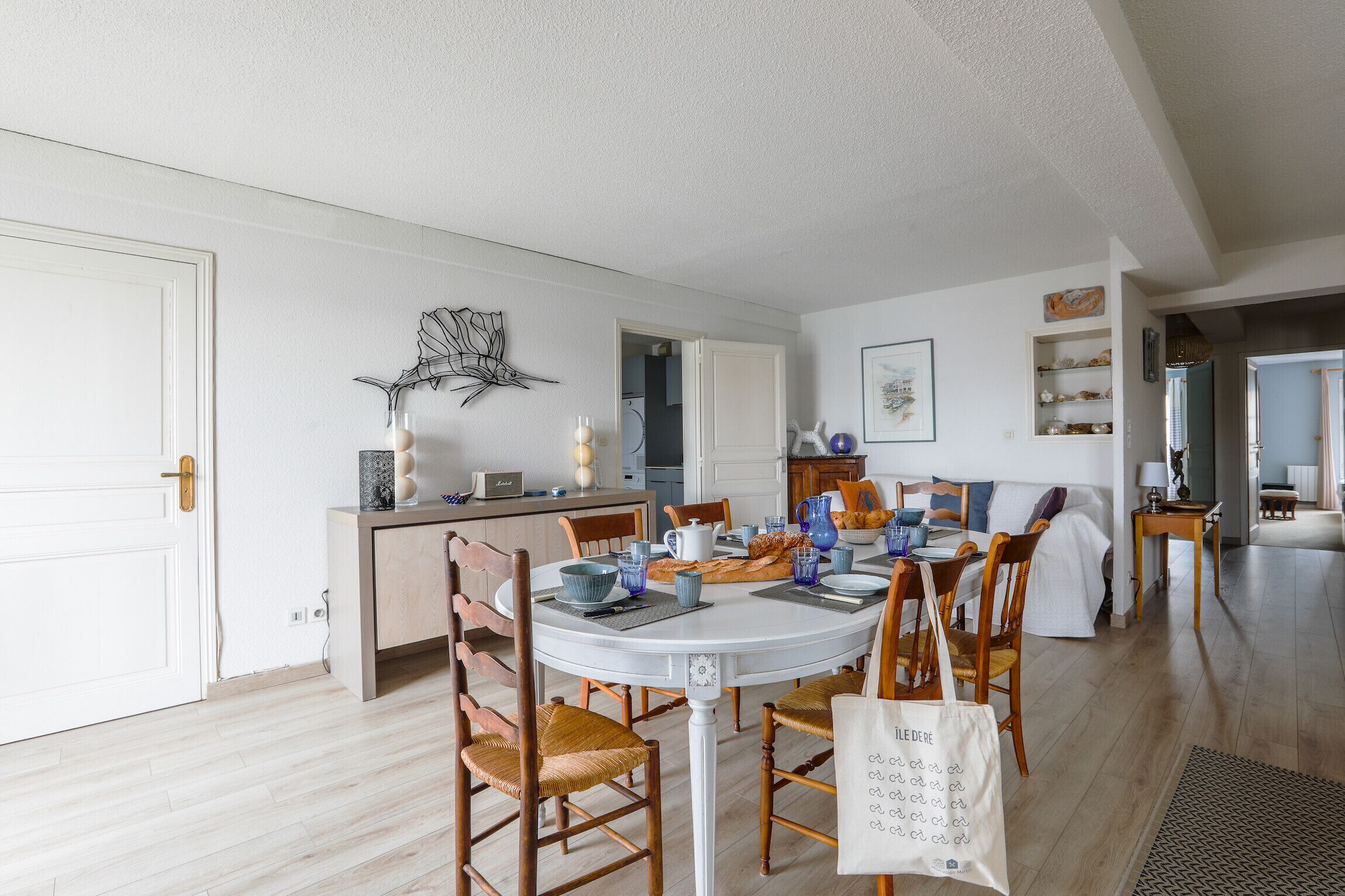 Un coin repas avec une table ronde, des chaises et une cuisine en arrière-plan.