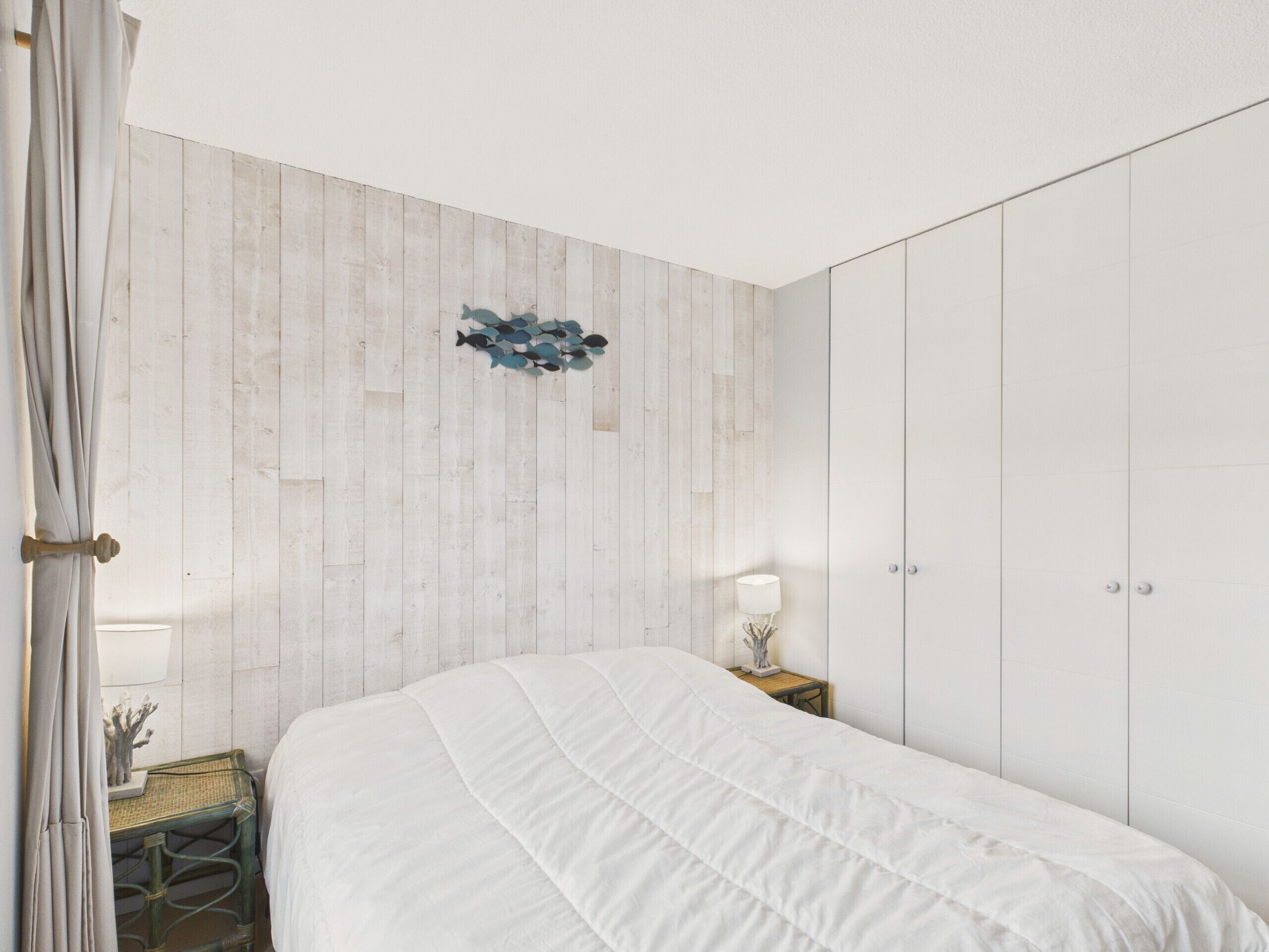 Une chambre à coucher avec un lit, une table de chevet, une lampe et une armoire.