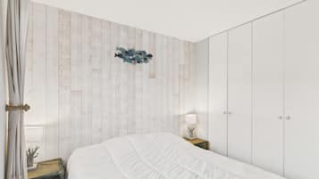 Une chambre à coucher avec un lit, une table de chevet, une lampe et une armoire.