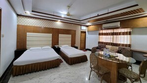 A hotel room with two beds, a dining table with chairs, an air conditioning unit, and a patterned wall. - Hotel Sea World Cox's Bazar (Cox's Bazar)