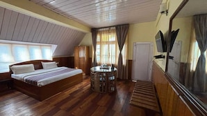 Une chambre à coucher avec un lit, une table ronde et un grand miroir.