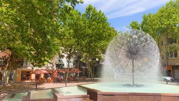 Une fontaine publique dont l’élément central est une installation aquatique, le tout étant entouré d’une zone pavée.