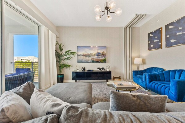 Enchanting living area of the condo in Kissimmee Florida - Well-chosen lighting fixtures adding both functionality and charm -TV with a large screen for entertainment - Stylish, contemporary furnishings enhancing the aesthetic - Amazing Mickey Mouse-themed 2BR near Disney! (Kissimmee)