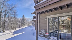 A snow-covered outdoor area with a building featuring a balcony with chairs and a table. - Idyllic Somerset Condo: Ski, Hike & Relax! (Somerset)