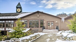 A building with a clock tower, labeled "Hidden Valley Resort," featuring large windows, a front door, and steps leading up to the entrance. - Idyllic Somerset Condo: Ski, Hike & Relax! (Somerset)