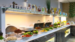 A buffet setup with various food items and condiments. - Grand Zara Otel (Kayseri)