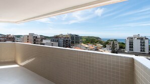 Ein Balkon mit Fliesenwänden und Blick auf Stadt und Meer.