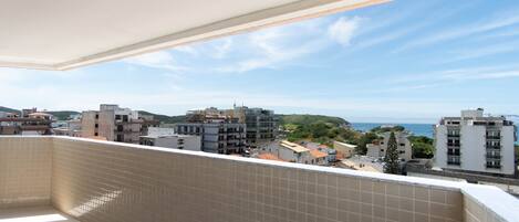 Un balcón con paredes de azulejos y vista a la ciudad y al mar.