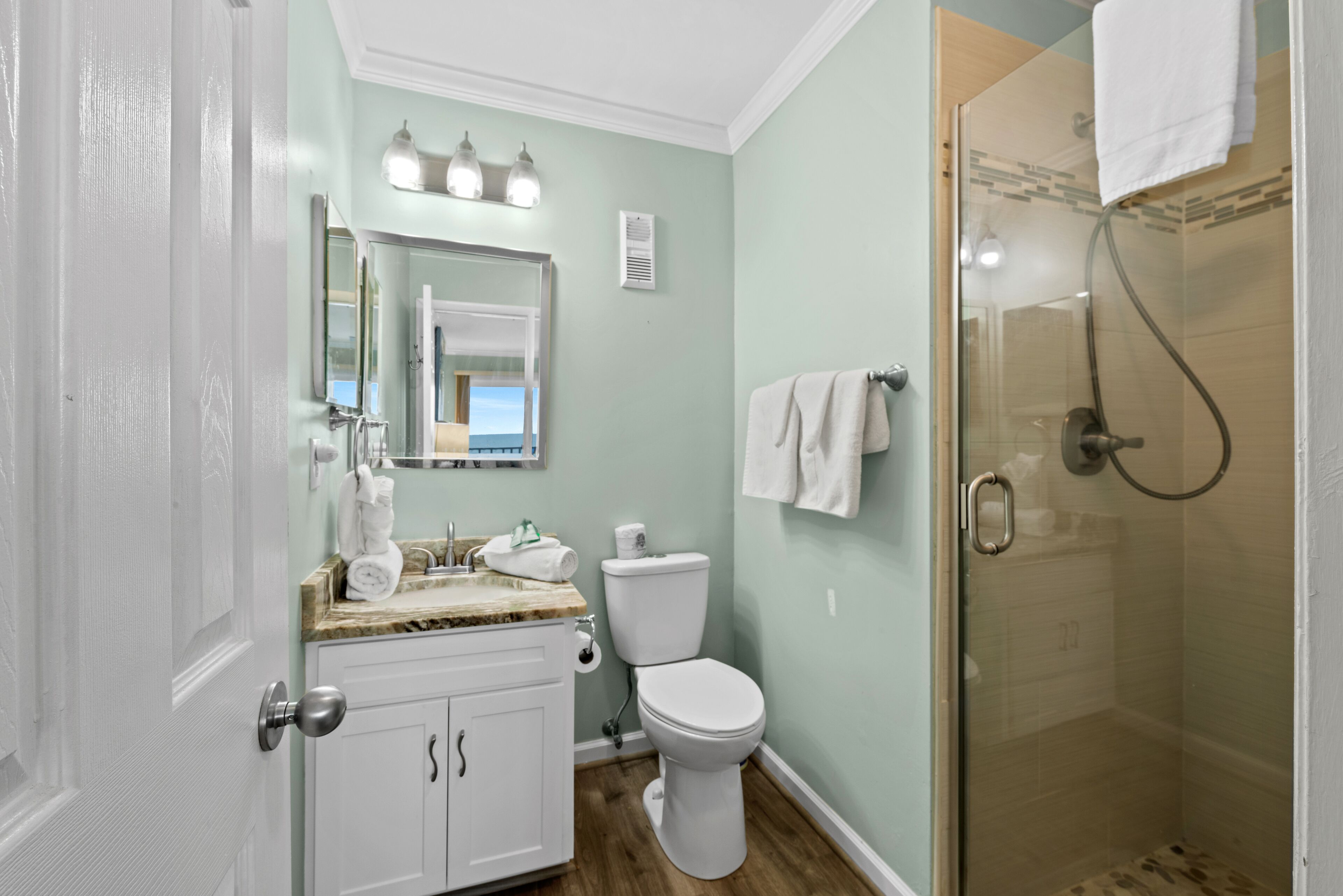 Une salle de bain avec des toilettes, un lavabo et une douche.