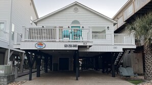 Un immeuble de deux étages doté d’un balcon et d’une enseigne sur laquelle on peut lire « Ocean Breeze 913 ».