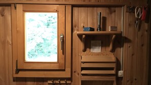 A wooden cabin interior with a window, a shelf with a flashlight, and a paper towel holder. - Lovingly furnished Alphüttli (Wilderswil)