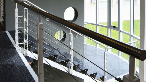 A multi-level interior with a staircase, large windows, and a view of the outdoors. - Hotel Bait (General Roca)