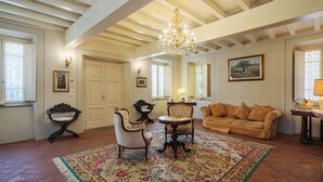 A spacious living room with a large floral rug, a wooden coffee table, a sofa, and a chandelier. - Villa / Independent home in Lucca with 9 bedrooms sleeps 18 (Lucca)