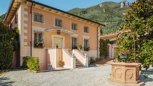 A two-story building with a beige facade, a central entrance with a staircase, and a gravel driveway. - Villa / Independent home in Lucca with 9 bedrooms sleeps 18 (Lucca)