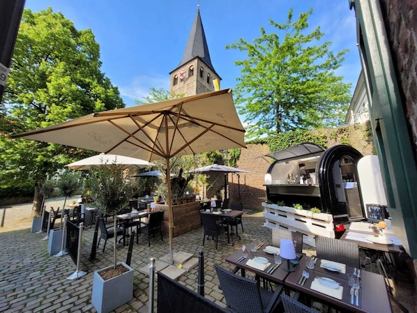 Enjoy al fresco dining in a charming outdoor space with a brick wall, traditional tower, and modern grill station.