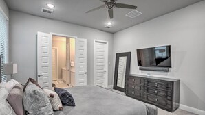A bedroom with a bed, dresser, TV, and a ceiling fan. - Patio & Game Room: Frisco Family Getaway! (Frisco)