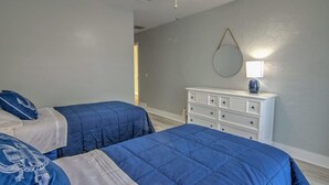 A bedroom with two beds, a ceiling fan, a dresser, and a wall-mounted mirror. - Naples Park House w/Heated Pool, Near Beaches (Naples)
