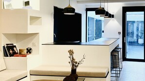 A modern kitchen with a central island, pendant lighting, and a view to the outdoors.