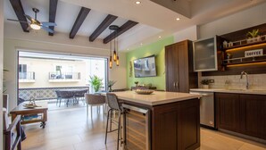 Een moderne keuken met een centraal eiland, houten kastjes en een inbouw vaatwasser.