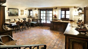 Una cocina rústica con una isla grande, muebles de madera y un comedor con banco.