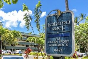 A sign for 'Kahana Reef' indicating 'All Ocean Front Apartments' with the number 4471.