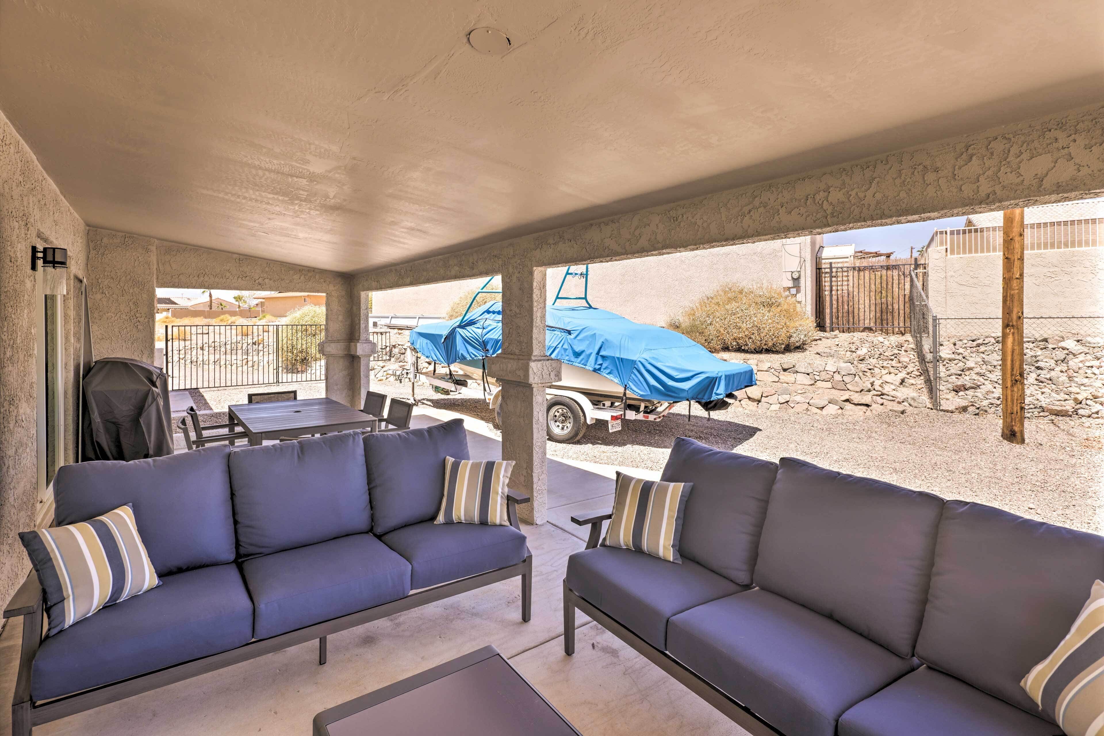 A covered patio area with two dark-colored sofas and a small table.