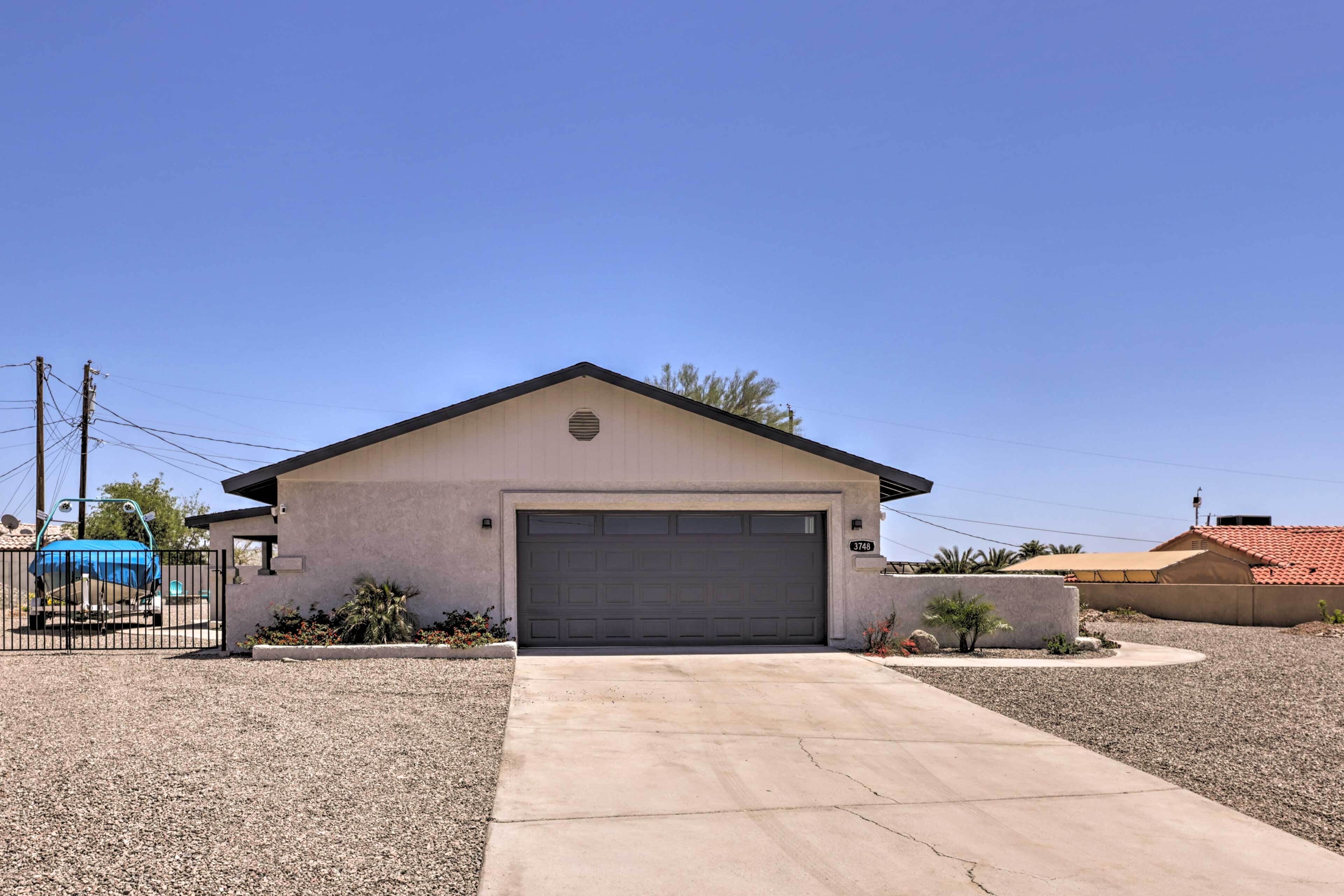 A single-story house with a garage, a driveway, and a small garden area.