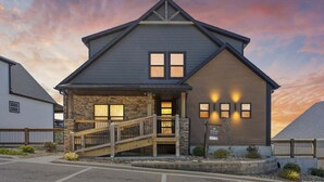 A two-story building with a stone facade, a wooden staircase, and a sign indicating it is a university. - Westview - Indoor pool & lake views (Branson)