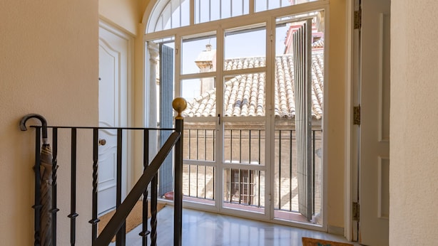 Eine Treppe mit schwarzer Geländer zur Tür mit Glasfenster.