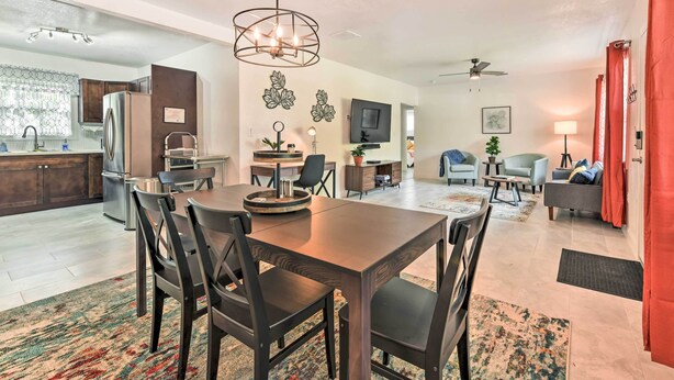 A modern kitchen with a dining area, a living room with a sofa and TV, and a ceiling fan. - Bright, Pet-Friendly Retreat in Avon Park! (Avon Park)