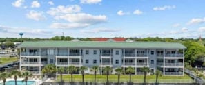 A multi-story hotel with a green roof, multiple balconies, and a pool area. - HARBORWALK Destin with boatdock (Destin)